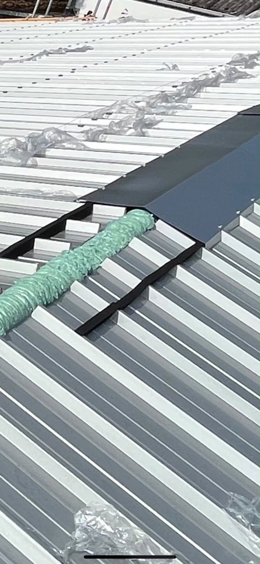 Montage von Firstblech auf neuem hellen Trapezblechdach