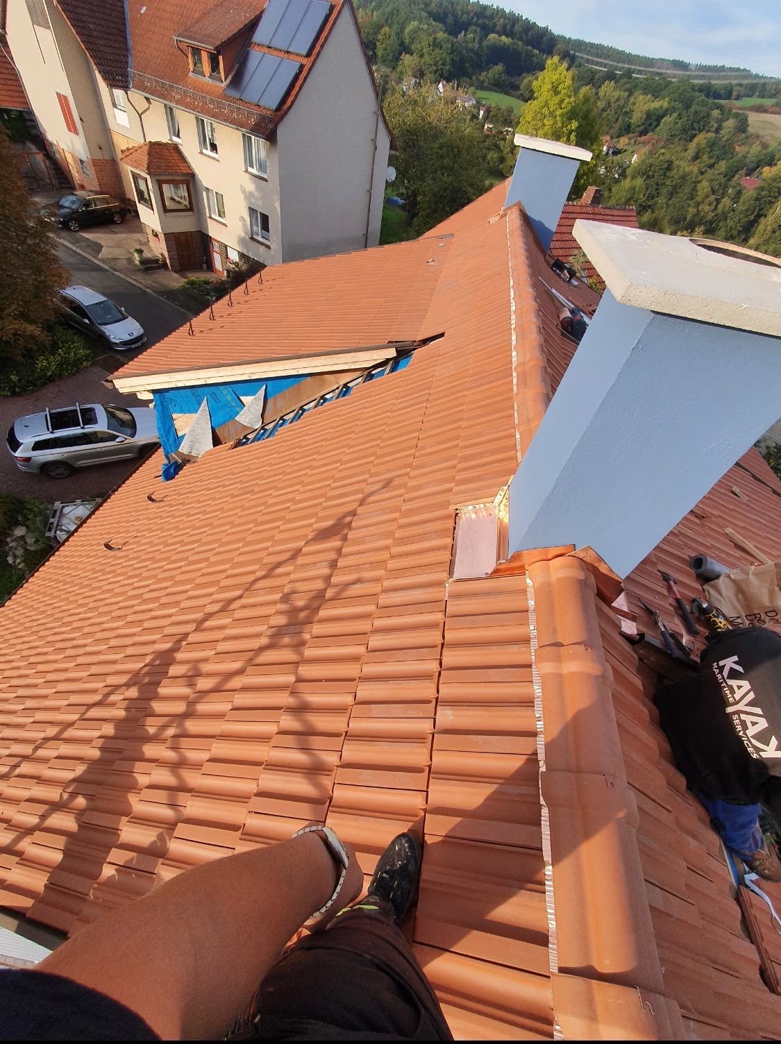 Verlegung neuer orangeroter Ziegel mit freier Bahnfläche am First